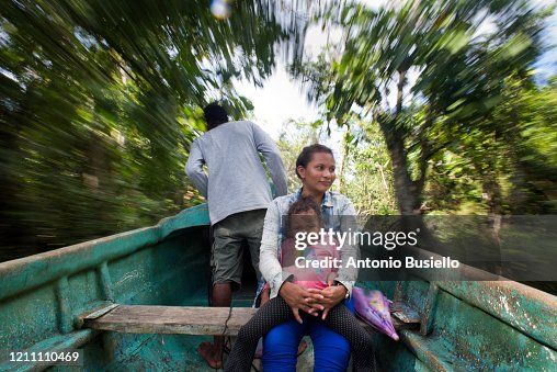 Familia navegando en canoa por el río, entre la vegetación